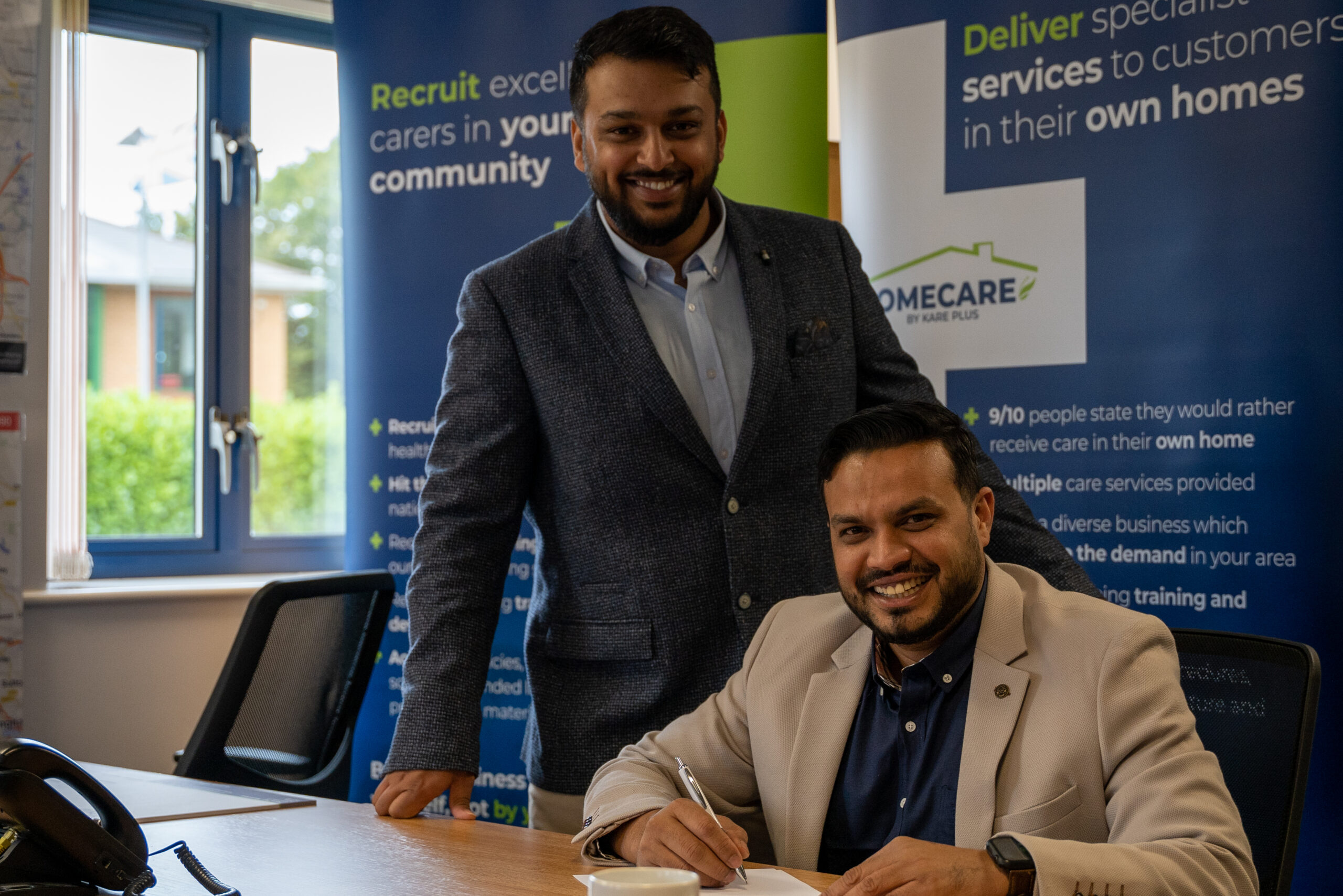 Image of two recent Kare Plus franchisees signing their agreement.